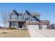 Charming two-story home with blue siding, brick accents, and a three-car garage under a clear blue sky at 19149 Gillcrest Dr, Noblesville, IN 46062