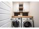 Convenient laundry area equipped with modern washer and dryer units, white cabinets, and butcher block countertop at 19149 Gillcrest Dr, Noblesville, IN 46062