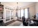 Bright office with built-in bookshelves, french doors, a modern chandelier, and beautiful hardwood floors at 19149 Gillcrest Dr, Noblesville, IN 46062