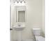Clean bathroom featuring a pedestal sink, toilet, a decorative mirror, and a light fixture at 19511 Grassy Branch Rd, Westfield, IN 46074