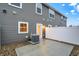 Back patio featuring white vinyl fence, door, concrete pad, gravel, and HVAC system at 19511 Grassy Branch Rd, Westfield, IN 46074