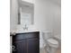 Modern bathroom features a dark vanity with white countertop, stylish mirror, and standard toilet at 2150 Aviary Ln, Danville, IN 46122