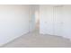 A bedroom with neutral colored carpet, an open door, and sliding door closet at 2150 Aviary Ln, Danville, IN 46122