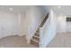 Bright entryway with luxury vinyl plank floors, white walls, and carpeted stairs at 2150 Aviary Ln, Danville, IN 46122