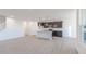 Open-concept kitchen with gray cabinets, white island, and wood-look flooring adjacent to a staircase at 2150 Aviary Ln, Danville, IN 46122