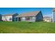 The backyard has a spacious lawn, with young trees planted and a covered patio at 2349 S Copperstone Dr, New Palestine, IN 46163
