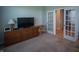 Versatile bonus room, furnished with a wooden dresser and adjacent to French doors at 2349 S Copperstone Dr, New Palestine, IN 46163