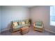 Bright sitting room with sofa, chair, wicker coffee table, and window at 2349 S Copperstone Dr, New Palestine, IN 46163
