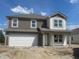 Two-story home with neutral colors, white trim, covered porch, and a two car garage at 24409 Stout St, Sheridan, IN 46069