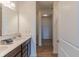Bathroom with double sinks, wood look floors, white walls, and a walk-in closet view at 275 Hunters Ridge Dr, Danville, IN 46122