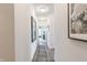 Long hallway with neutral walls, art, and dark wood look laminate flooring at 275 Hunters Ridge Dr, Danville, IN 46122