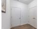 Hallway with laminate flooring, white walls, and doors with brushed nickel hardware at 275 Hunters Ridge Dr, Danville, IN 46122