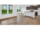 Open-concept kitchen and living area with bright light and wood-look flooring at 275 Hunters Ridge Dr, Danville, IN 46122