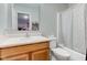 Cozy bathroom with white tiled shower, wood cabinets, with a large mirror to enhance the space at 3039 Armory Dr, Indianapolis, IN 46208