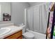 Cozy bathroom with white tiled shower, wood cabinets, with a large mirror to enhance the space at 3039 Armory Dr, Indianapolis, IN 46208