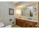 Bathroom featuring dual sinks, framed artwork, and wallpaper, evoking a vintage charm at 3810 Springfield Overlook St, Indianapolis, IN 46234
