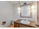 Traditional bathroom with floral framed mirror, lighting sconces, and wood vanity at 3810 Springfield Overlook St, Indianapolis, IN 46234