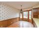 Traditional dining room featuring a chandelier, wood paneling, and a bay window for natural light at 3810 Springfield Overlook St, Indianapolis, IN 46234