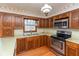 Kitchen showcasing stainless steel appliances, wood cabinets, and a double-basin sink underneath a window at 3810 Springfield Overlook St, Indianapolis, IN 46234