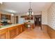 Open kitchen area with wood cabinets, a built-in desk, and access to a dining space at 3810 Springfield Overlook St, Indianapolis, IN 46234