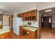 Eat-in kitchen features vintage cabinets, wallpaper, and adjoining dining area at 3810 Springfield Overlook St, Indianapolis, IN 46234