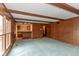 Retro living room with wood paneling, beams, blue carpeting and bar area at 3810 Springfield Overlook St, Indianapolis, IN 46234