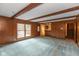 Spacious living room featuring wood paneling, beamed ceilings, and a glimpse into an adjacent room at 3810 Springfield Overlook St, Indianapolis, IN 46234
