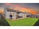 A view of the backyard featuring a wood deck with a grill and patio set, enhanced by a vibrant sunset at 4051 Presidio Cir, Indianapolis, IN 46235