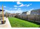 Back yard of a home, showcasing a green lawn with a wood fence and deck at 4051 Presidio Cir, Indianapolis, IN 46235