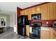 Well-lit kitchen with ample wooden cabinetry, black appliances, and modern finishes at 4051 Presidio Cir, Indianapolis, IN 46235