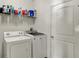 Functional laundry room with modern washer and dryer, plus overhead shelving for storage at 4051 Presidio Cir, Indianapolis, IN 46235