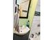 Bathroom with a white sink, light green walls, and a shower/tub with tile surround and patterned shower curtain at 428 N Alton Ave, Indianapolis, IN 46222