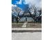 Quaint home with a stone facade, metal security door, and trees in front under a bright sky at 428 N Alton Ave, Indianapolis, IN 46222