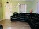Cozy living room with green walls, featuring a large black leather sectional and neutral laminate flooring at 428 N Alton Ave, Indianapolis, IN 46222