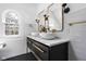 Modern bathroom with dual sinks, gold fixtures, black floors, and a large arched window at 4310 Central Ave, Indianapolis, IN 46205