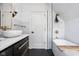 Modern bathroom with a soaking tub, glass shower door, vanity with black floors and gold fixtures at 4310 Central Ave, Indianapolis, IN 46205