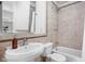A tiled bathroom featuring a toilet, tub, and sink with a mirror, with neutral color tones at 4310 Central Ave, Indianapolis, IN 46205