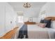 Bright bedroom with hardwood floors, two windows, a wooden dresser, and a comfortable queen bed at 4310 Central Ave, Indianapolis, IN 46205
