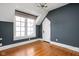 Attic bedroom with hardwood floors, blue accent wall, dormer window, and vaulted ceilings at 4310 Central Ave, Indianapolis, IN 46205