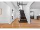 Bright foyer with wood floors, black staircase, white walls, and archways to other rooms at 4310 Central Ave, Indianapolis, IN 46205