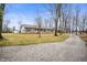 Ranch-style home featuring neutral siding, green shutters, a gravel driveway, and an American flag at 4543 E 700 N, Alexandria, IN 46001