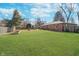 A sprawling green backyard framed by a wooden fence, offers ample space for outdoor activities and relaxation at 4905 N Dearborn St, Indianapolis, IN 46205