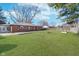 Large, grassy backyard with full lawn, bordered by a wood fence and the home's brick exterior at 4905 N Dearborn St, Indianapolis, IN 46205