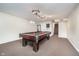 Basement featuring a pool table, unique light fixture, nearby staircase, and neutral carpeting at 4905 N Dearborn St, Indianapolis, IN 46205