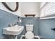 Charming powder room with blue walls, a vessel sink, and a wood-framed round mirror at 4905 N Dearborn St, Indianapolis, IN 46205