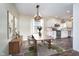 Open-concept dining area and kitchen with white cabinets, stainless steel appliances, and stylish lighting at 4905 N Dearborn St, Indianapolis, IN 46205