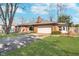 Well-maintained brick home with an attached garage and a lush green lawn in a residential area at 4905 N Dearborn St, Indianapolis, IN 46205