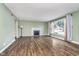 Bright living room featuring hardwood floors, a fireplace, and a large window at 4905 N Dearborn St, Indianapolis, IN 46205