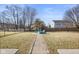 View of the backyard with a stone path leading to a fire pit surrounded by blue Adirondack chairs at 5630 N Rockingham Ln, McCordsville, IN 46055