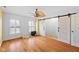 Bright bedroom with hardwood floors, shuttered windows, and barn door closet access at 5630 N Rockingham Ln, McCordsville, IN 46055